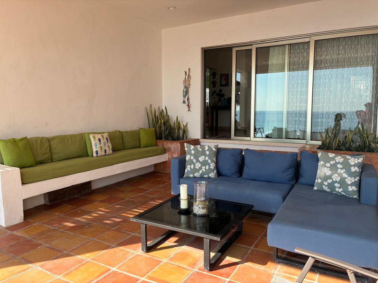 Patio cubierto con sillones y vista al mar